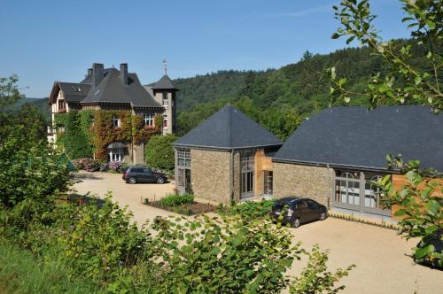 ein großes Haus mit davor geparkt in der Unterkunft Hotel La Ferronniere in Bouillon