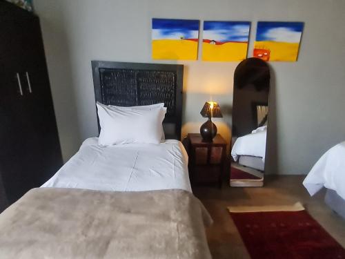 a bedroom with a large bed and a mirror at The Darling Farmstyle B&B in Krugersdorp