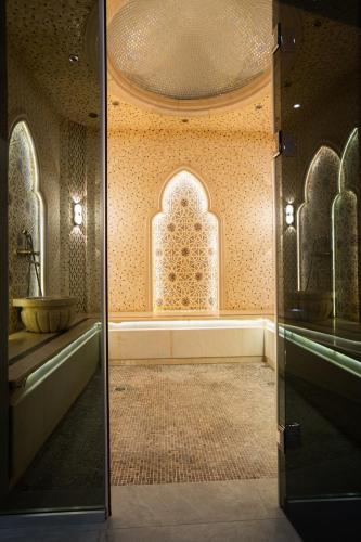a bathroom with a sink and a glass door at Al Anvar Halal Hotel by HotelPro group in Tashkent