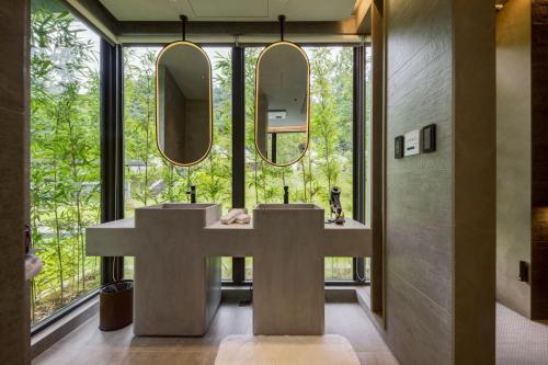 a bathroom with two sinks and a cross in front of a window at Sokali Maho 蘇卡利 漫活 in Chung-chih-ts'un