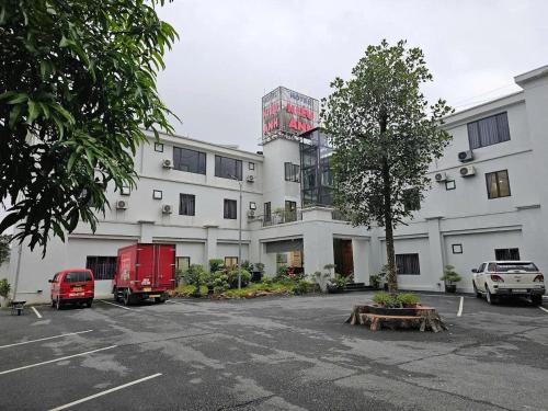a building with a red truck parked in a parking lot at Kieu Anh Hotel Phu Tho in Thanh Sơn