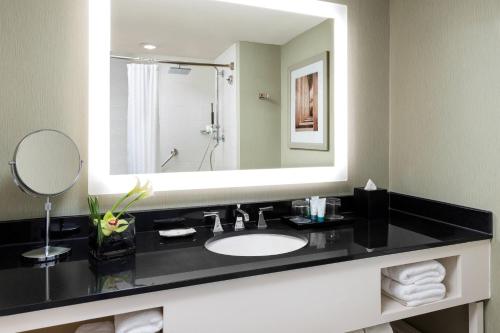 a bathroom with a sink and a large mirror at The Westin Arlington in Arlington