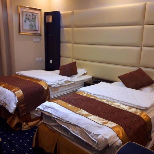 a room with three beds in a hotel room at اجواء المساء للشقق المخدومة in Wadi Al Dawasir