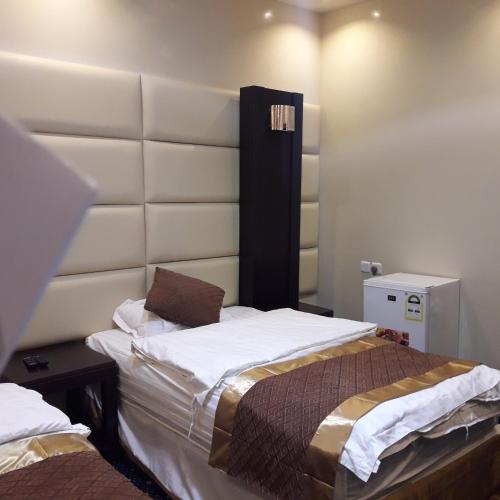 a bedroom with a large bed with a white headboard at اجواء المساء للشقق المخدومة in Wadi Al Dawasir