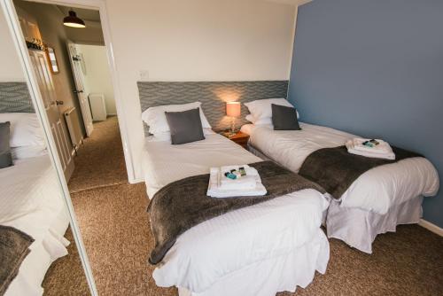 a room with three beds with towels on them at Surf View House in Newquay