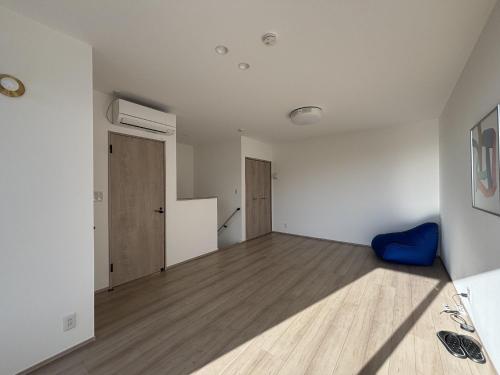an empty room with white walls and wooden floors at ひとめぼれ in Kumamoto