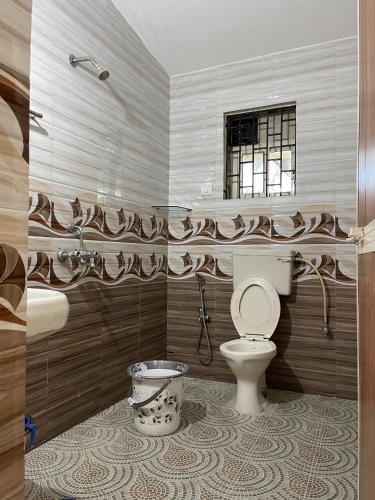 a bathroom with a toilet and a sink and a window at Cardozo beach house in Calangute