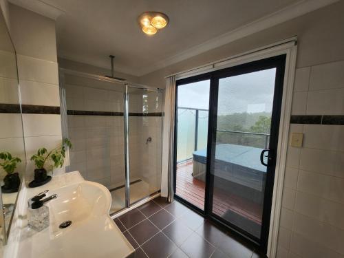 a bathroom with a sink and a shower with a view at Scarlet Woods Chalets in Quinninup