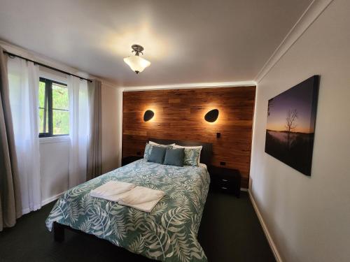 a small bedroom with a bed and a window at Scarlet Woods Chalets in Quinninup