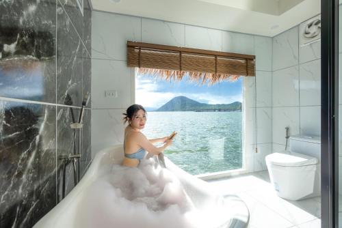 a woman sitting in a bathtub filled with foam at Ruknam Resort in Ban Hin Hak