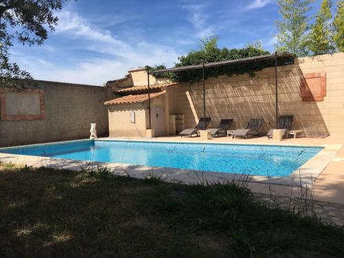 een zwembad met stoelen en een huis bij Villa des carassins in Saint-Rémy-de-Provence