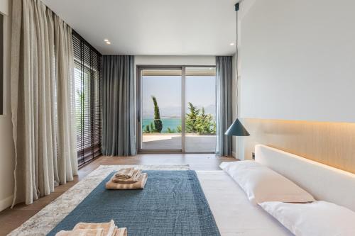a living room with a couch and a large window at Lake Whisper Villa Pool & Amazing Views by PikHost in Shirokë