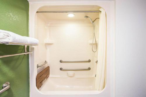 a small bathroom with a shower in a room at Quality Inn Kansas City International Airport in Kansas City