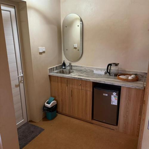 a bathroom with a sink and a mirror at Jabal Hatt Resthouse in Khawr Zammah