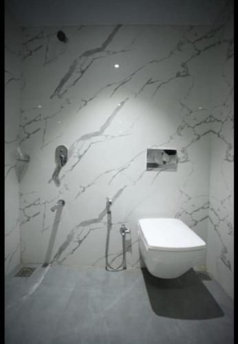 a bathroom with a toilet and a stone wall at The Byke Heritage - Pan India Pure Veg Hotel Chain in Matheran