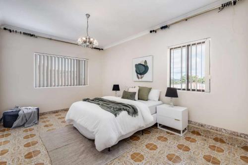 a white bedroom with a bed and a couch at Comfortable House-shared accommodation in Bankstown