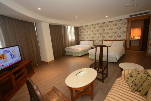 ein Hotelzimmer mit zwei Betten und einem Fernseher in der Unterkunft Apollo Hotel in Puli