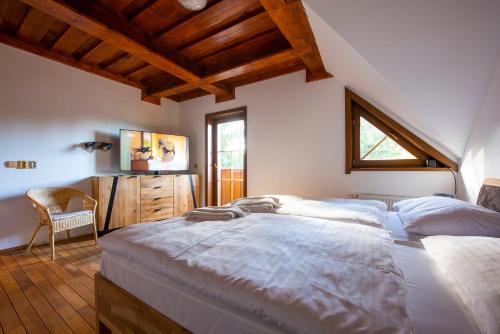 a bedroom with a large bed and a desk at Platanus by Hotel Pieris in Pribylina