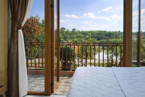 a bedroom with a bed and a balcony with a view at Khách sạn Đức Lộc Phát in Kiến Ðức