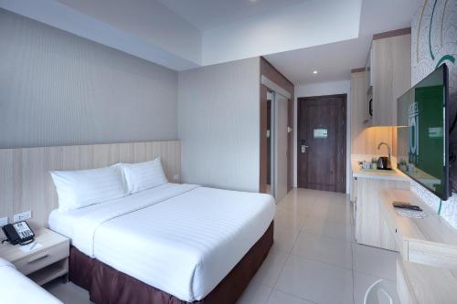 a hotel room with a bed and a television at Hotel101 - Fort in Manila