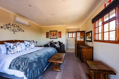 a bedroom with a bed and a couch at Intibane Lodge in Ulundi