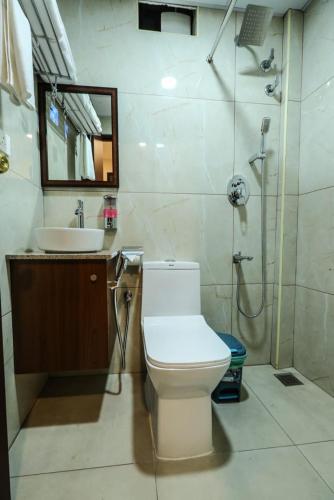 a bathroom with a toilet and a sink at Fair Stay Hotel in Cochin
