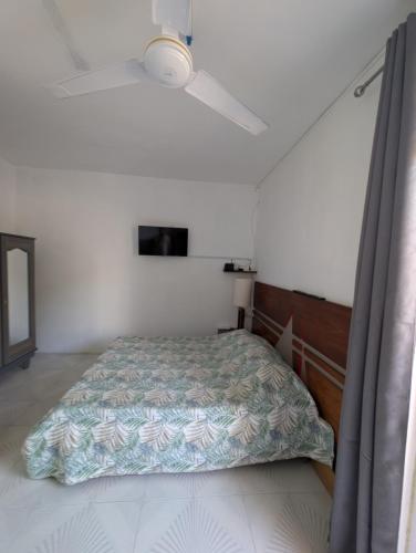 a bedroom with a bed and a ceiling fan at Desirella Villa studio in Mahébourg