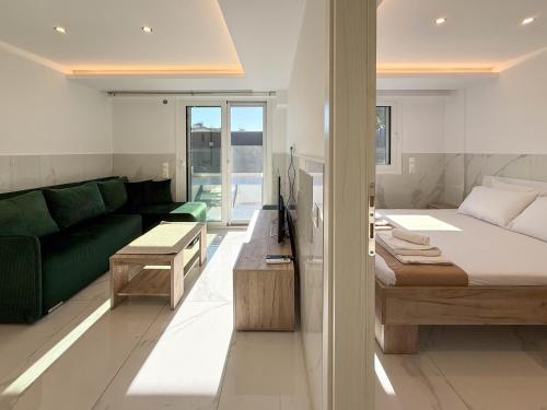 a bedroom with a bed and a green couch at MELISSA Suites By SDR in Paralia Katerinis