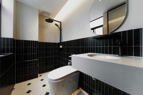 a bathroom with a toilet and a sink and a mirror at Good Night Hotel in Zhangjiajie