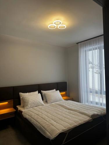 a bedroom with a large bed with a large window at Cottages Grun in Yablunytsya