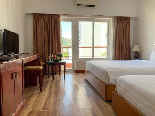 a hotel room with two beds and a television at Media Nha Trang Hotel in Nha Trang