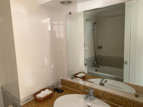 a bathroom with two sinks and a large mirror at Media Nha Trang Hotel in Nha Trang