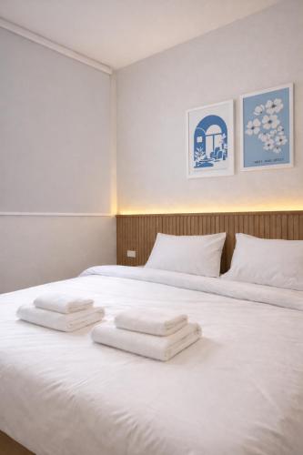 two white towels sitting on top of a bed at Soft Blue Home, Krabi Town in Krabi