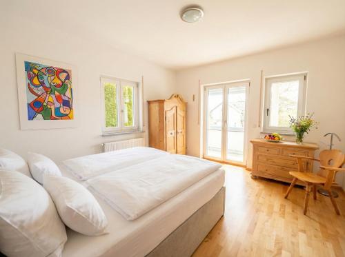 a bedroom with a large white bed and a desk at Bergperle am Lindberg in Perlesreut