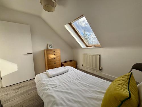 a bedroom with a bed and a skylight at Egham Modern Two Bedroom Apartment in Egham