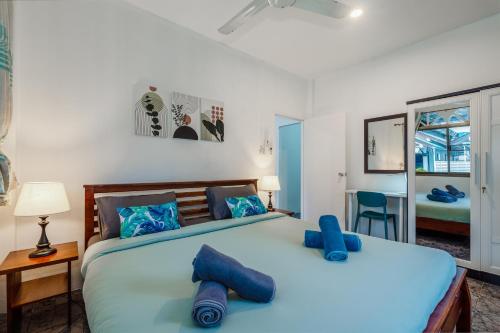a bedroom with a large bed with blue pillows at Karon Beach Holiday Home 1 in Karon Beach