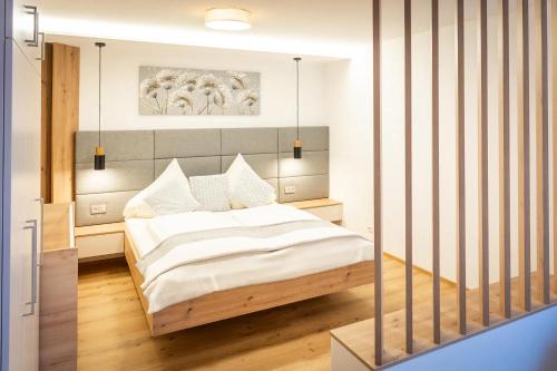 a bedroom with a bed with white sheets at Traumferienhaus XXL Ortner in Wetzendorf