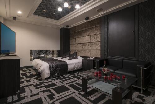 a hotel room with a bed and a tv at Hotel Pierrot Izumiotsu -Adult Only in Izumiotsu