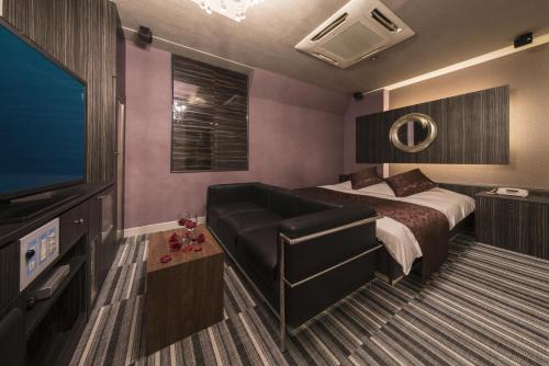 a bedroom with a bed and a flat screen tv at Hotel Pierrot Izumiotsu -Adult Only in Izumiotsu
