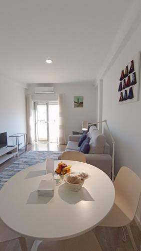 a living room with a white table and a couch at Coimbra's Black & White in Coimbra
