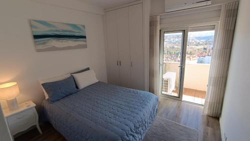 a bedroom with a bed and a large window at Coimbra's Black & White in Coimbra