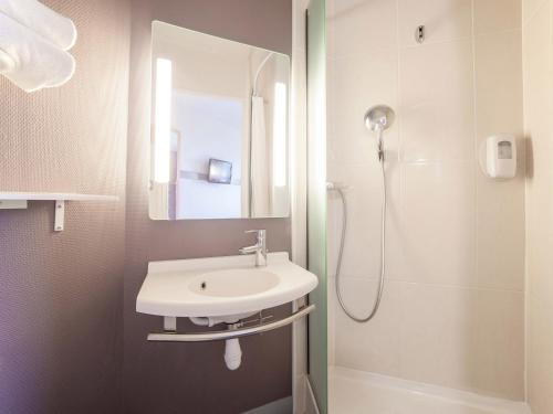 ein Bad mit einem Waschbecken und einer Dusche in der Unterkunft B&B HOTEL Marne-la-Vallée Bussy-Saint-Georges in Bussy-Saint-Georges