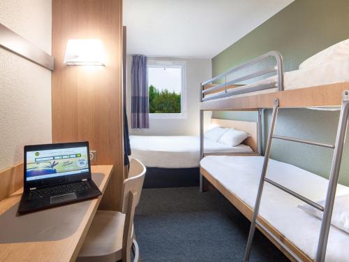 a room with two bunk beds and a laptop on a desk at B&B HOTEL Marne-la-Vallée Bussy-Saint-Georges in Bussy-Saint-Georges