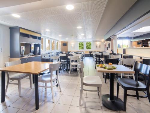 a dining room with tables and chairs at B&B HOTEL Marne-la-Vallée Bussy-Saint-Georges in Bussy-Saint-Georges