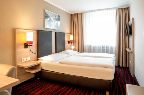 a hotel room with a bed and a window at Europäischer Hof in Munich