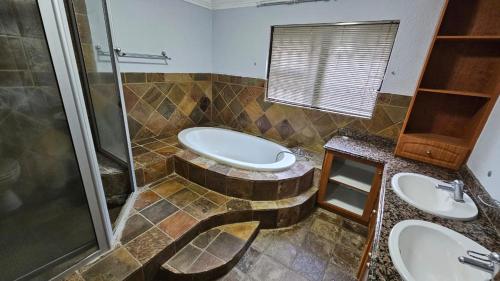 a bathroom with two sinks and a shower at Grobler's Haven On Vaal - Barrage in Tumahole