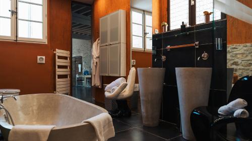 a bathroom with a large tub and a sink at Villa Troletti, hôtel particulier de luxe en Provence in L'Isle-sur-la-Sorgue