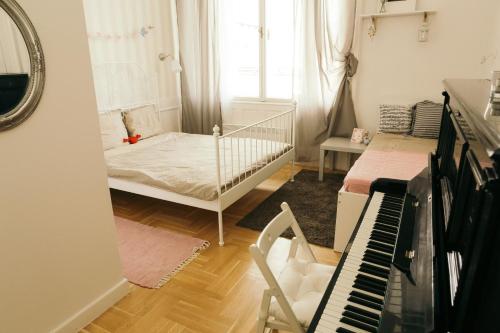 ブダペストにあるHello Puli Parliamentのベッドとピアノ付きの小さな部屋