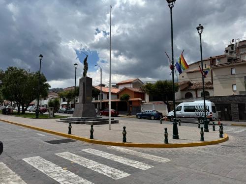 a statue in the middle of a street with flags at Templo de la Luna Pardo in Cusco