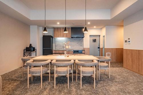 a kitchen with a large dining room table and chairs at Apartment Hotel 11 Nambaminami 5 in Osaka